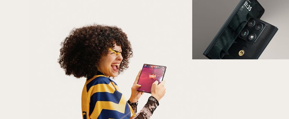 Osoba trzyma otwarty smartfon z dużym ekranem, ubrana w żółto-niebieską koszulkę. Obok widoczny jest zbliżony widok tylnej części smartfona z logo Motorola i godziną 11:35 na ekranie.