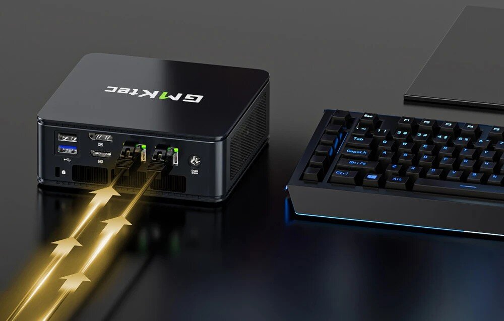 Na obrazie widoczny jest czarny komputer mini PC z logo \'GMKTEC\' oraz klawiatura z podświetleniem. Z komputera wychodzą złote strzałki symbolizujące połączenie lub przepływ danych.