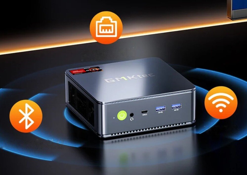 Na obrazie widoczny jest kompaktowy komputer z napisem \'GMKtec\' na górze obudowy. Wokół urządzenia znajdują się ikony symbolizujące Bluetooth, Ethernet i Wi-Fi.