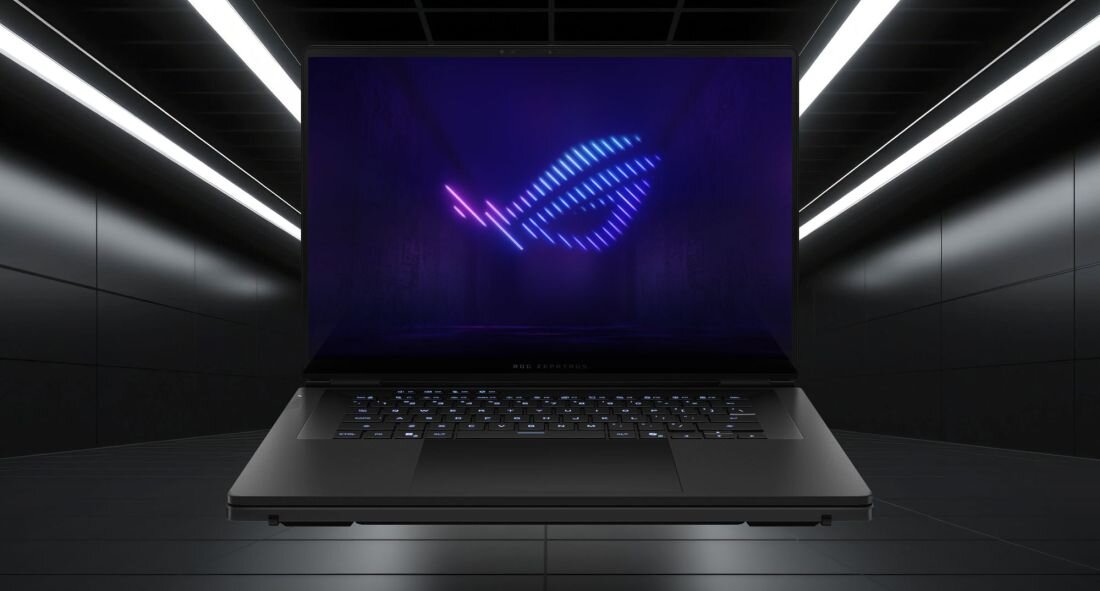 Laptop z podświetlaną klawiaturą i ekranem wyświetlającym kolorowe logo w ciemnym, nowoczesnym pomieszczeniu.