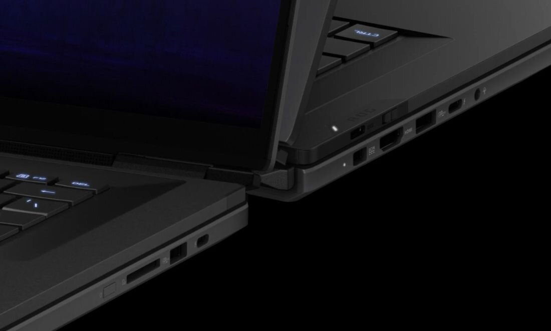 Zbliżenie na dwa laptopy z widocznymi portami i klawiaturą. Obudowy są w kolorze czarnym, a na jednym z laptopów widoczny jest napis \'media expert\'.