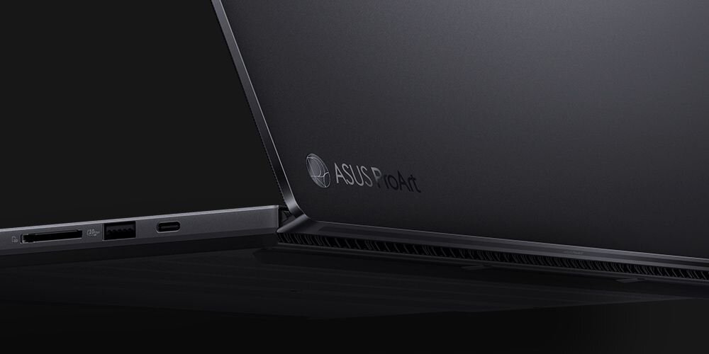 Czarny laptop z widocznym logo \'ASUS ProArt\' na obudowie. Widać porty USB, HDMI i czytnik kart pamięci.