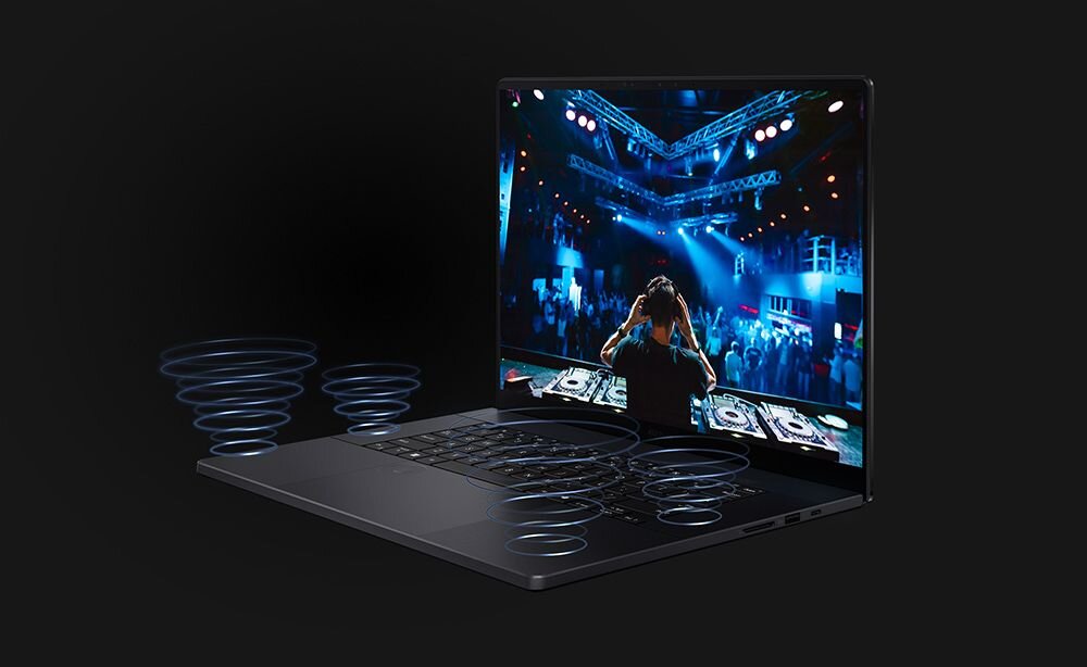 Laptop z otwartym ekranem wyświetlającym scenę koncertową z DJ-em. Wokół laptopa widoczne są graficzne fale dźwiękowe na ciemnym tle.