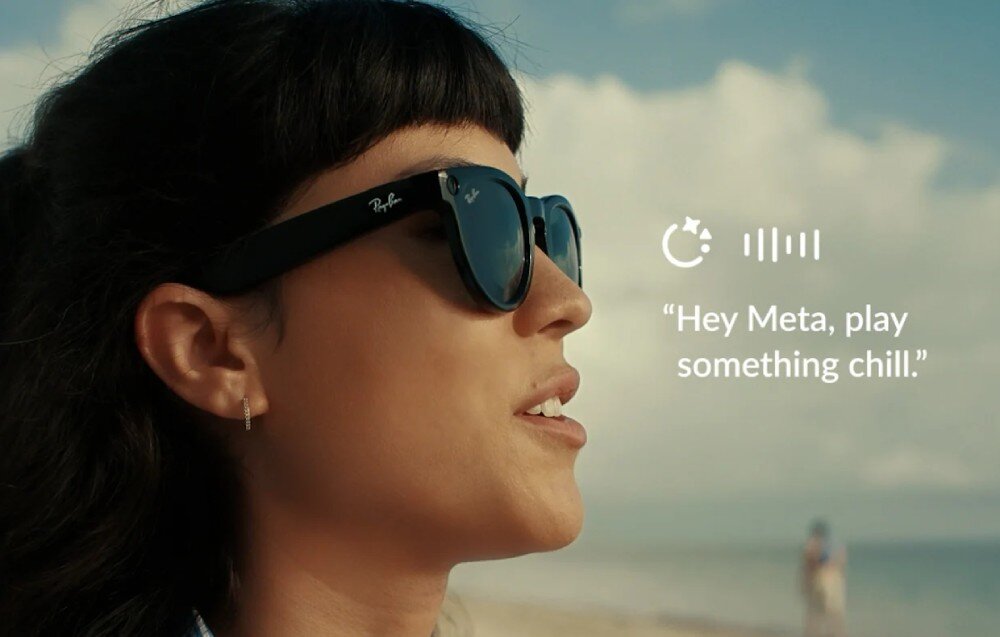 Osoba nosi czarne okulary przeciwsłoneczne z widocznym logo \'Ray-Ban\'. Obok znajduje się tekst: \'Hey Meta, play something chill.\'