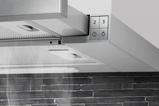 Fragment okapu kuchennego z widocznymi przyciskami oznaczonymi cyframi 2 i 3 oraz ikonami włącznika i oświetlenia. W tle ceglana ściana, a z okapu wydobywa się para.