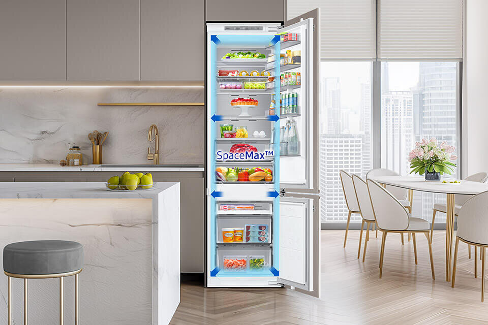 Wnętrze nowoczesnej kuchni z otwartą lodówką wypełnioną różnorodnymi produktami spożywczymi. Na drzwiach lodówki widoczny jest napis \'SpaceMax™\'.