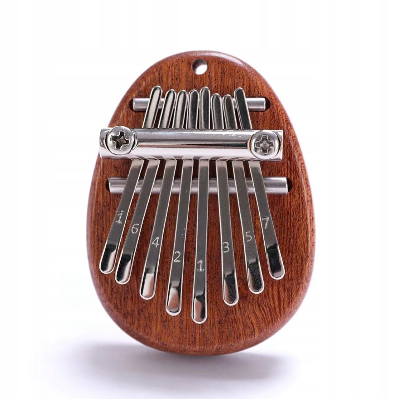 Na zdjęciu widoczna jest mini kalimba wykonana z drewna mahoniowego z metalowymi klawiszami. Na klawiszach znajdują się wygrawerowane liczby: 1, 6, 4, 2, 1, 3, 5, 7.