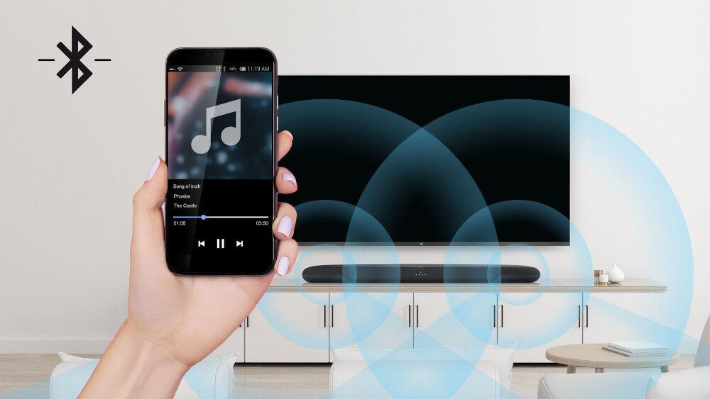 Na obrazie widać rękę trzymającą smartfon z wyświetlonym odtwarzaczem muzyki, a w tle znajduje się telewizor z soundbarem na szafce. Po lewej stronie widoczna jest ikona Bluetooth.