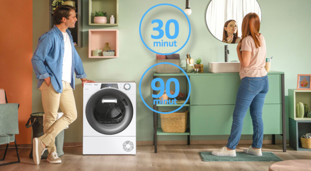 W pomieszczeniu znajduje się suszarka z widocznym bębnem, obok której stoi mężczyzna. Na obrazie widoczne są napisy \'30 minut\' i \'90 minut\'.