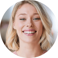 Zdjęcie przedstawia osobę z krótkimi blond włosami, uśmiechającą się szeroko.