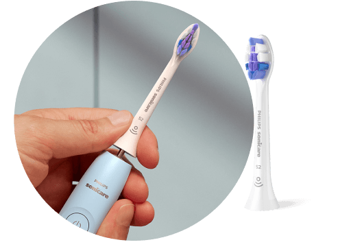 Na zdjęciu widoczna jest niebieska szczoteczka soniczna z białą główką, trzymana w dłoni. Obok znajduje się zbliżenie na samą główkę szczoteczki z niebieskimi i białymi włóknami, z napisem \'PHILIPS Sonicare\'.