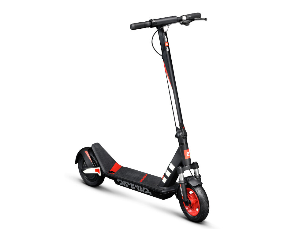 Czarno-czerwona hulajnoga elektryczna z widocznym logo \'aprilia\' na podeście. Posiada amortyzację i czerwone elementy na kołach oraz kierownicy.