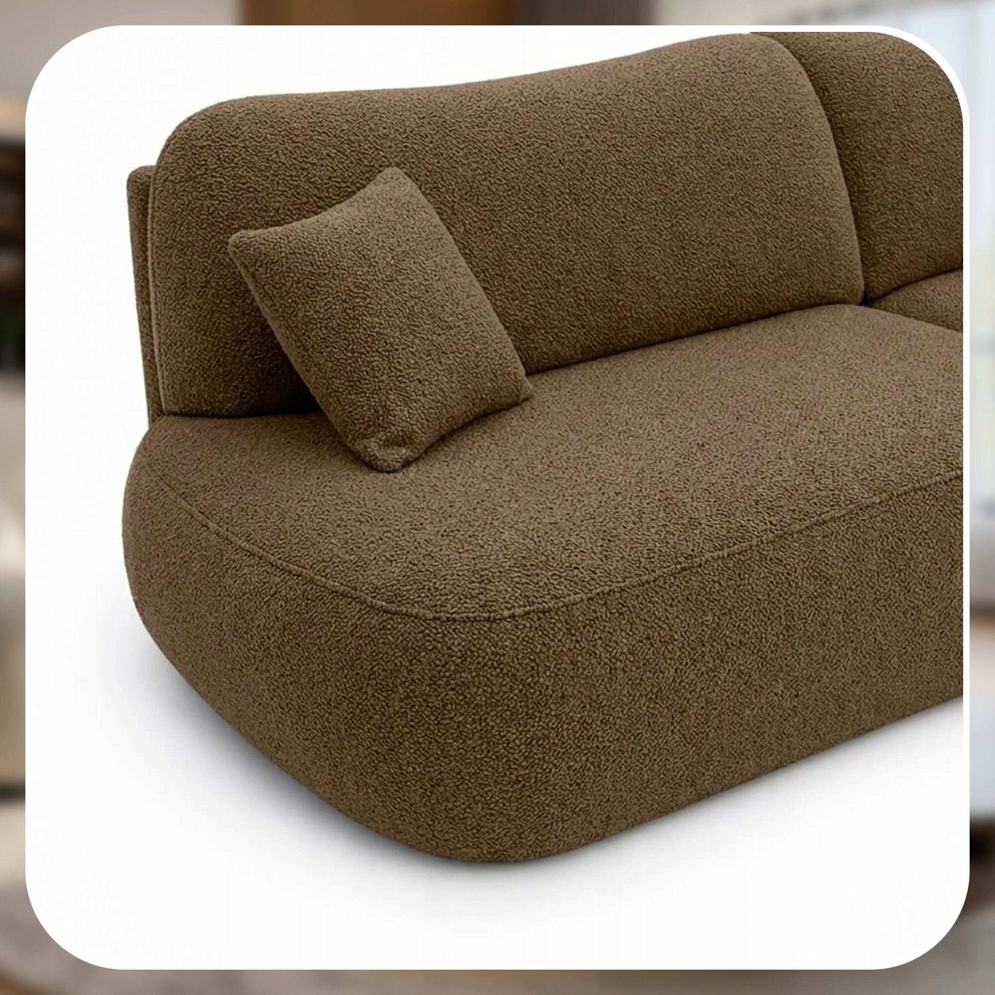 Brązowa sofa o zaokrąglonych kształtach z dopasowaną poduszką na siedzisku. Tkanina ma teksturę przypominającą plusz.