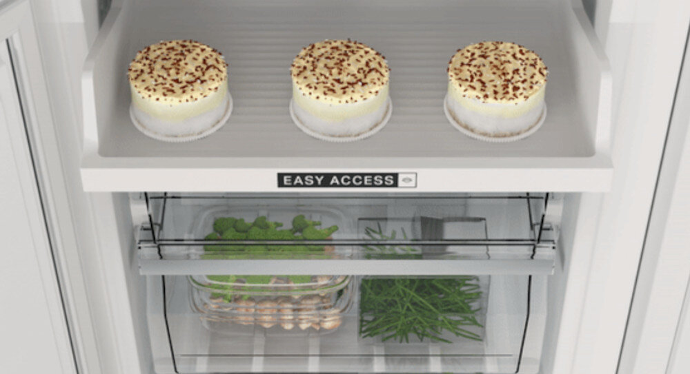 Wnętrze lodówki z trzema deserami na półce oznaczonej napisem \'EASY ACCESS\'. Poniżej znajdują się dwie szuflady z warzywami i jajkami.