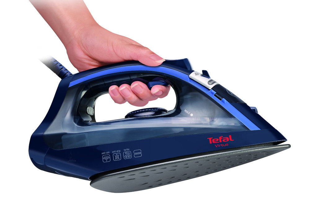 Osoba trzyma żelazko w kolorze granatowym z widocznym logo \'Tefal Virtuo\'. Na obudowie znajdują się symbole dotyczące ustawień prasowania.
