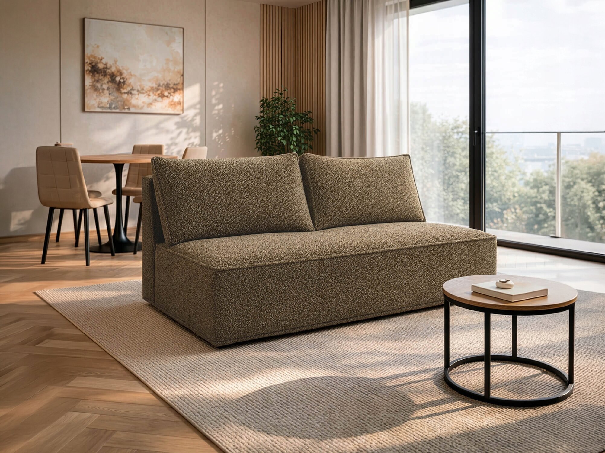 Na obrazie znajduje się brązowa sofa rozkładana ustawiona na jasnym dywanie w nowoczesnym salonie. W tle widać stół z krzesłami oraz duże okno z widokiem na zewnątrz.