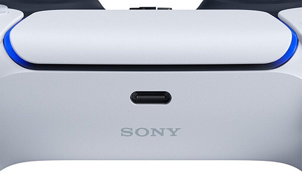 Zbliżenie na biały kontroler z widocznym logo \'SONY\' oraz portem ładowania. Kontroler ma niebieskie podświetlenie na krawędziach.