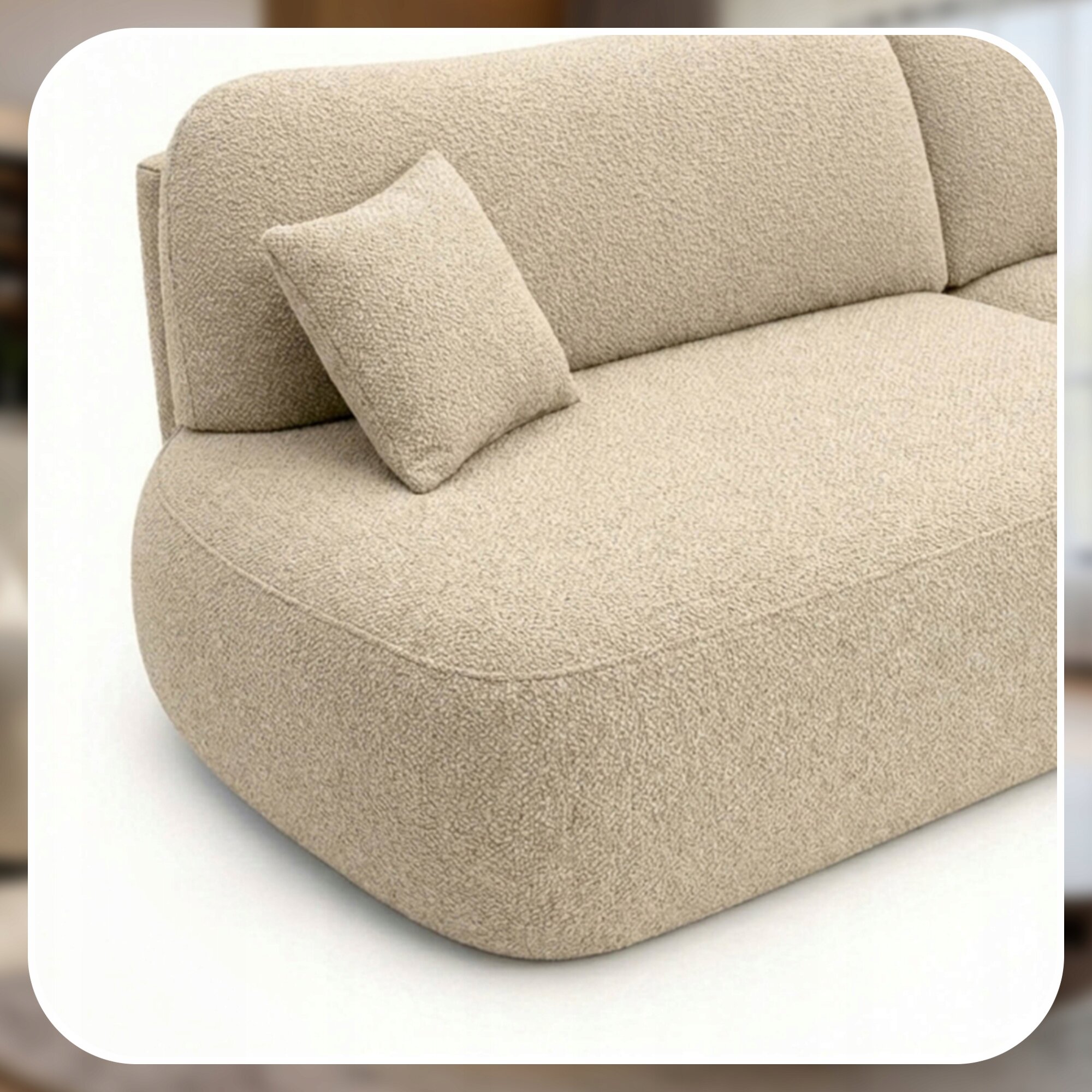 Beżowa sofa o zaokrąglonych kształtach z poduszką na siedzisku. Sofa ma teksturę przypominającą tkaninę boucle.