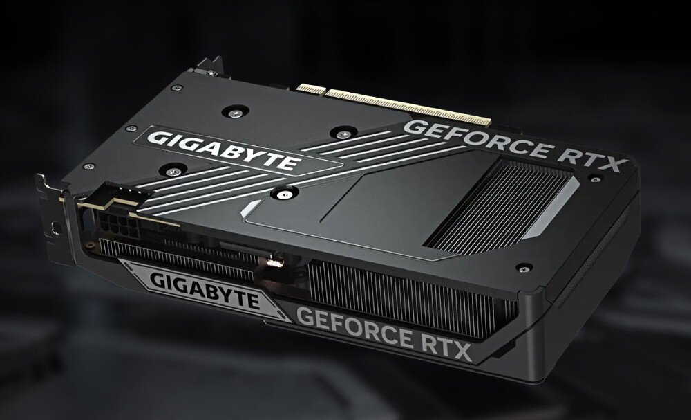Na obrazie widoczna jest karta graficzna z napisem \'GIGABYTE\' oraz \'GEFORCE RTX\'. Karta ma ciemną obudowę z metalicznymi elementami i widocznymi otworami wentylacyjnymi.