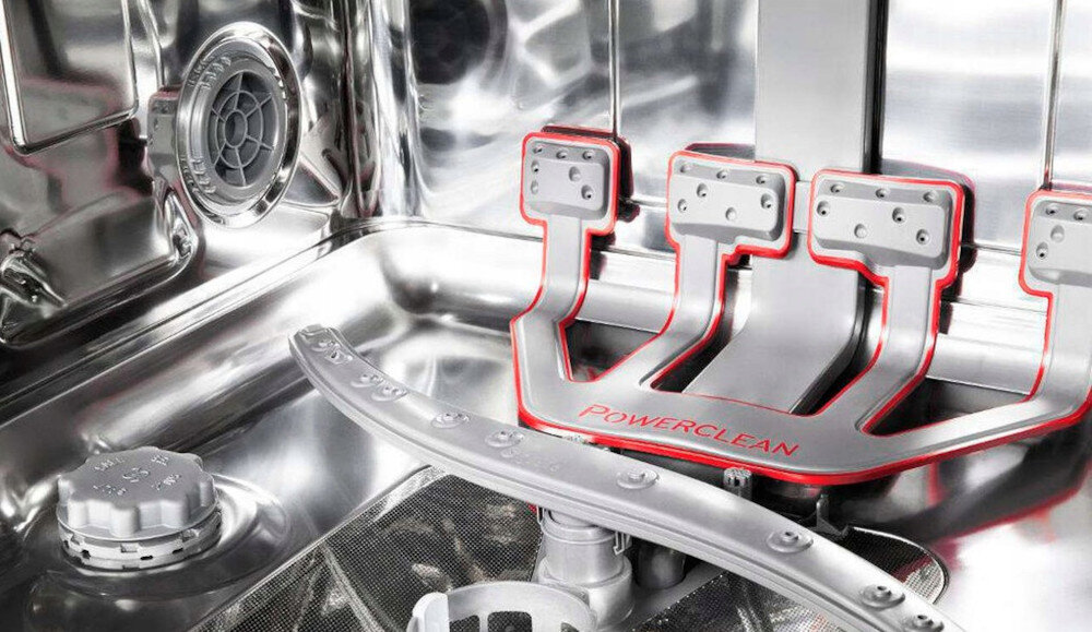 Wnętrze zmywarki z widocznym systemem PowerClean, oznaczonym napisem \'PowerClean\'. Elementy są wykonane z metalu i plastiku, z wyraźnymi dyszami i kratkami wentylacyjnymi.