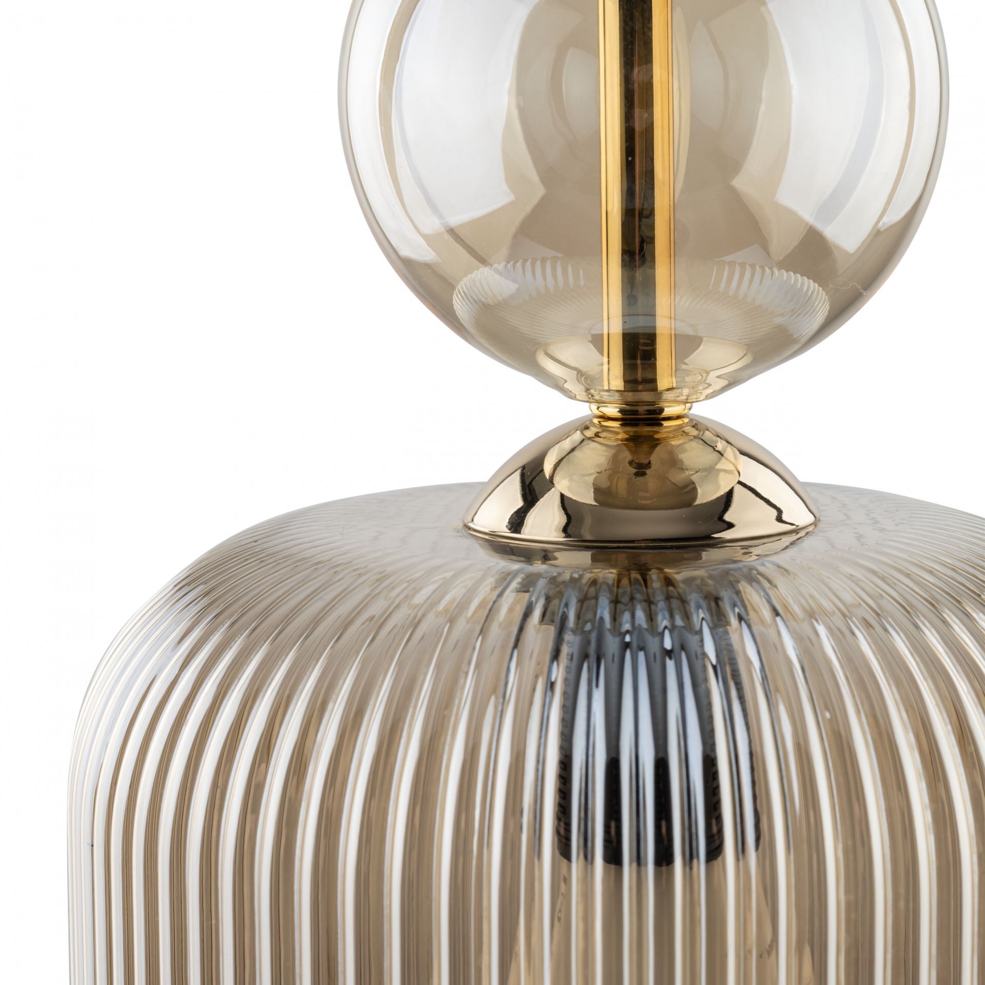 Zbliżenie na lampę wiszącą z bursztynowym, żebrowanym kloszem i złotymi elementami. Klosz ma kulisty kształt, a całość wykonana jest z przezroczystego materiału.