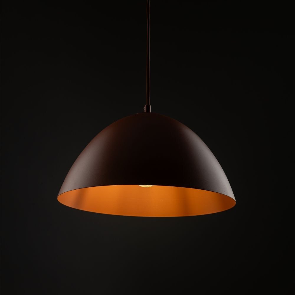 Lampa wisząca o półkulistym kształcie w kolorze ceglasto-pomarańczowym, z widocznym źródłem światła wewnątrz. Tło jest ciemne, co podkreśla kolor lampy.