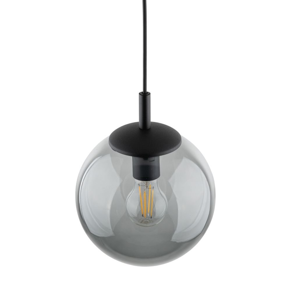 Lampa wisząca z przezroczystym, kulistym kloszem i widoczną żarówką wewnątrz. Klosz jest zawieszony na czarnym przewodzie z czarną oprawką.