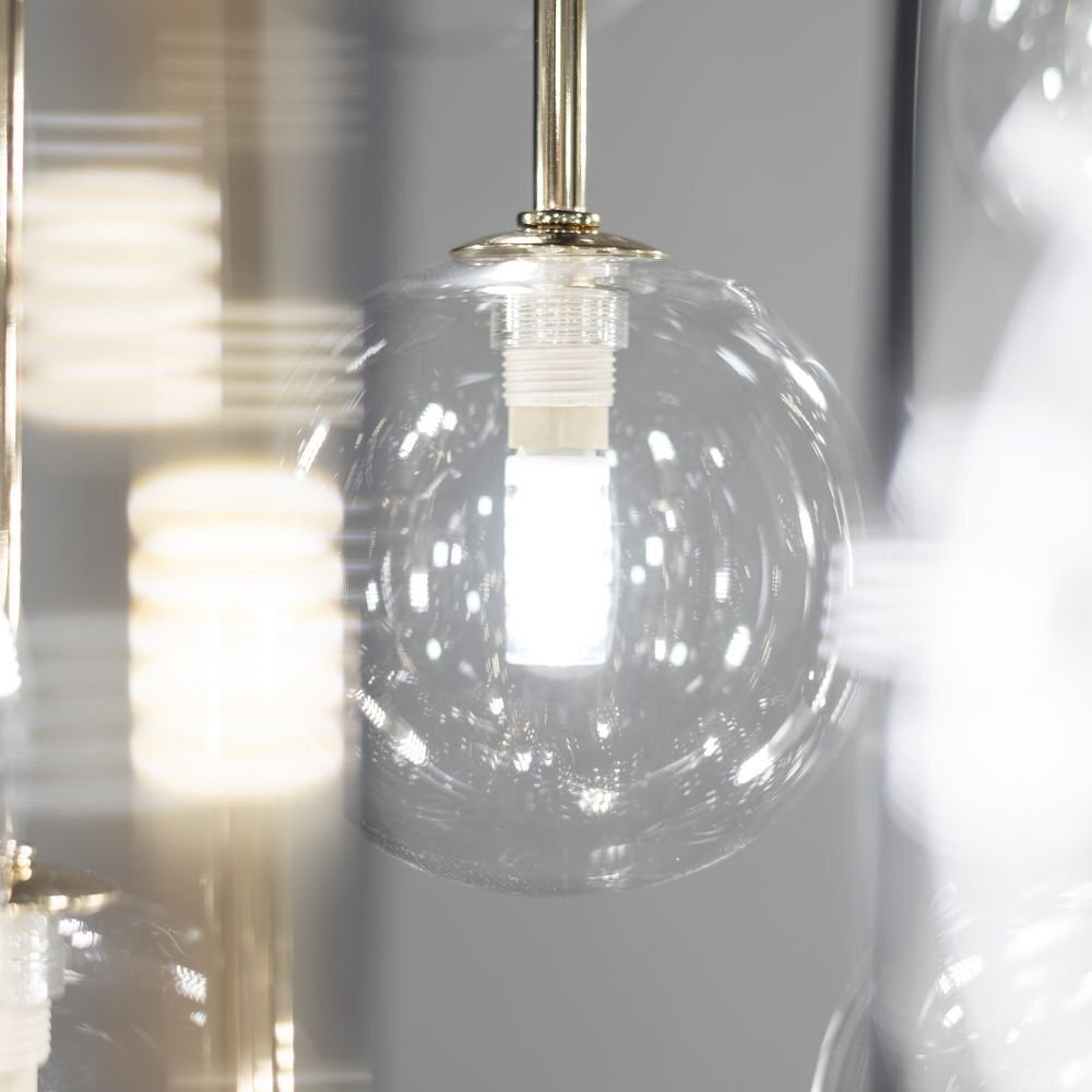 Zdjęcie przedstawia szklany klosz lampy wiszącej z widoczną żarówką wewnątrz. Elementy lampy mają czarno-złote wykończenie.