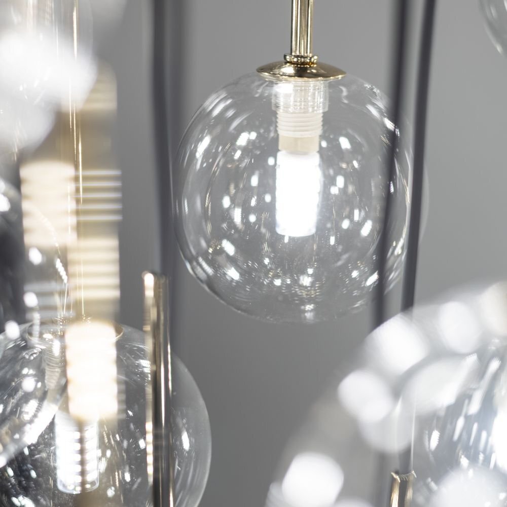 Zdjęcie przedstawia szklany klosz lampy wiszącej z widoczną żarówką wewnątrz. Elementy lampy mają czarno-złote wykończenie.