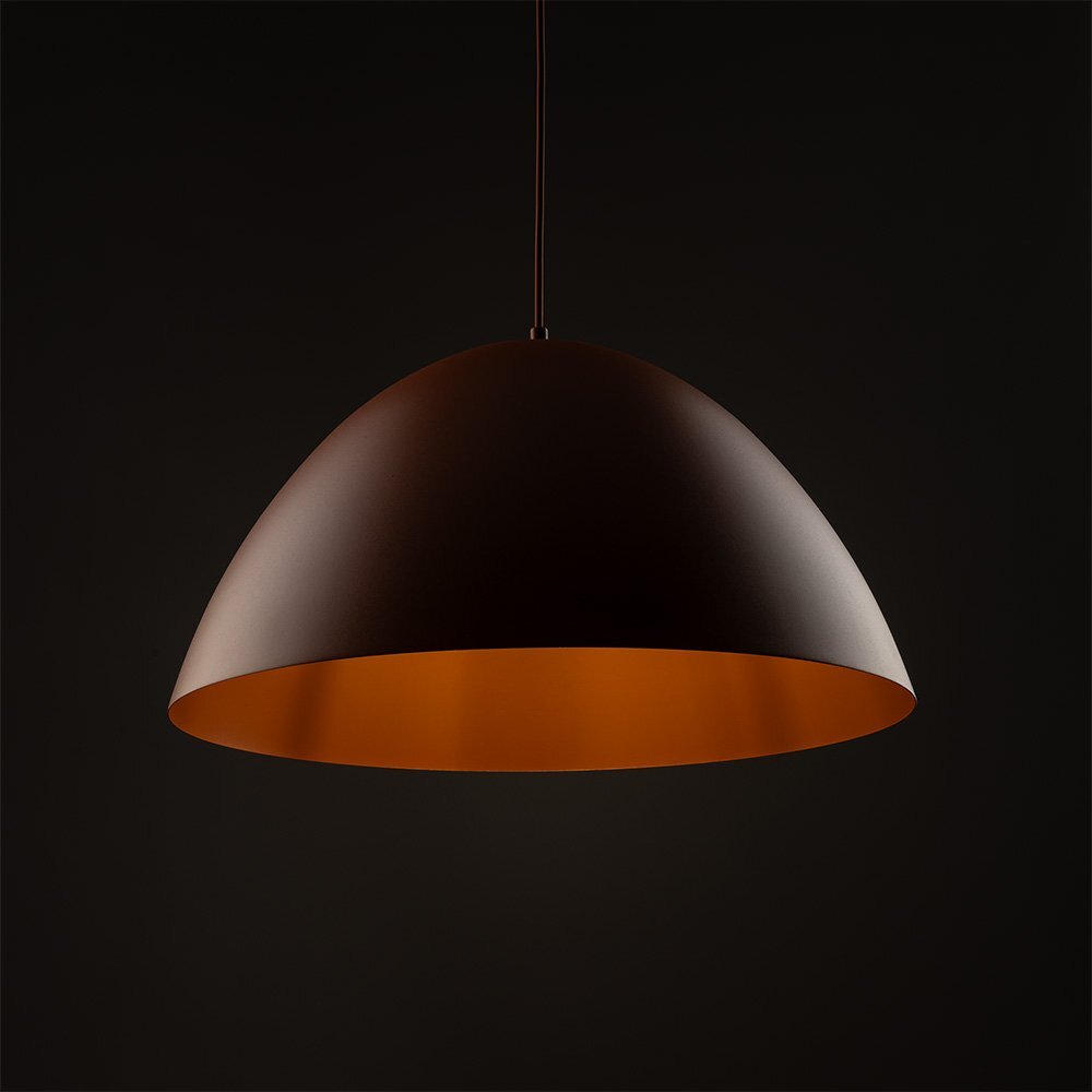 Na obrazie widoczna jest lampa wisząca o półkulistym kształcie w kolorze ceglastym. Tło jest ciemne, co podkreśla kolor lampy.