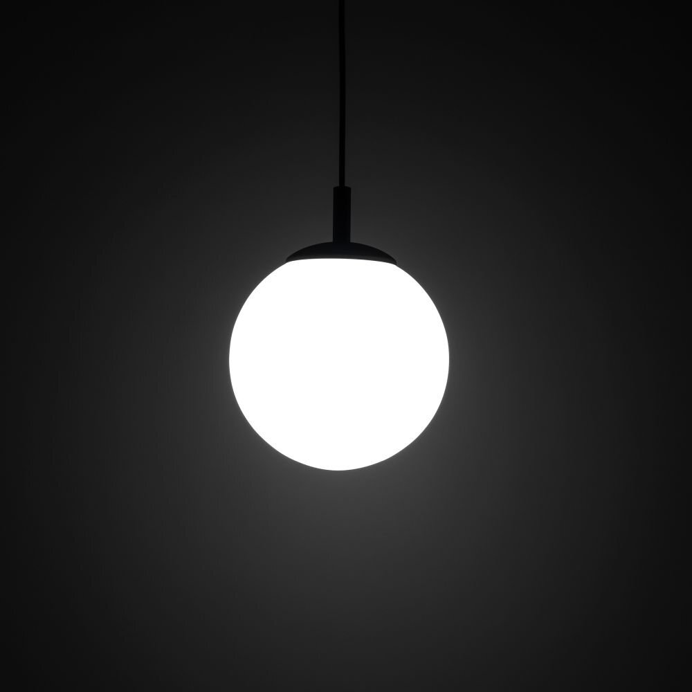 Na obrazie widoczna jest wisząca lampa z kulistym, jasnym kloszem. Tło jest ciemne, co podkreśla intensywność światła emitowanego przez lampę.