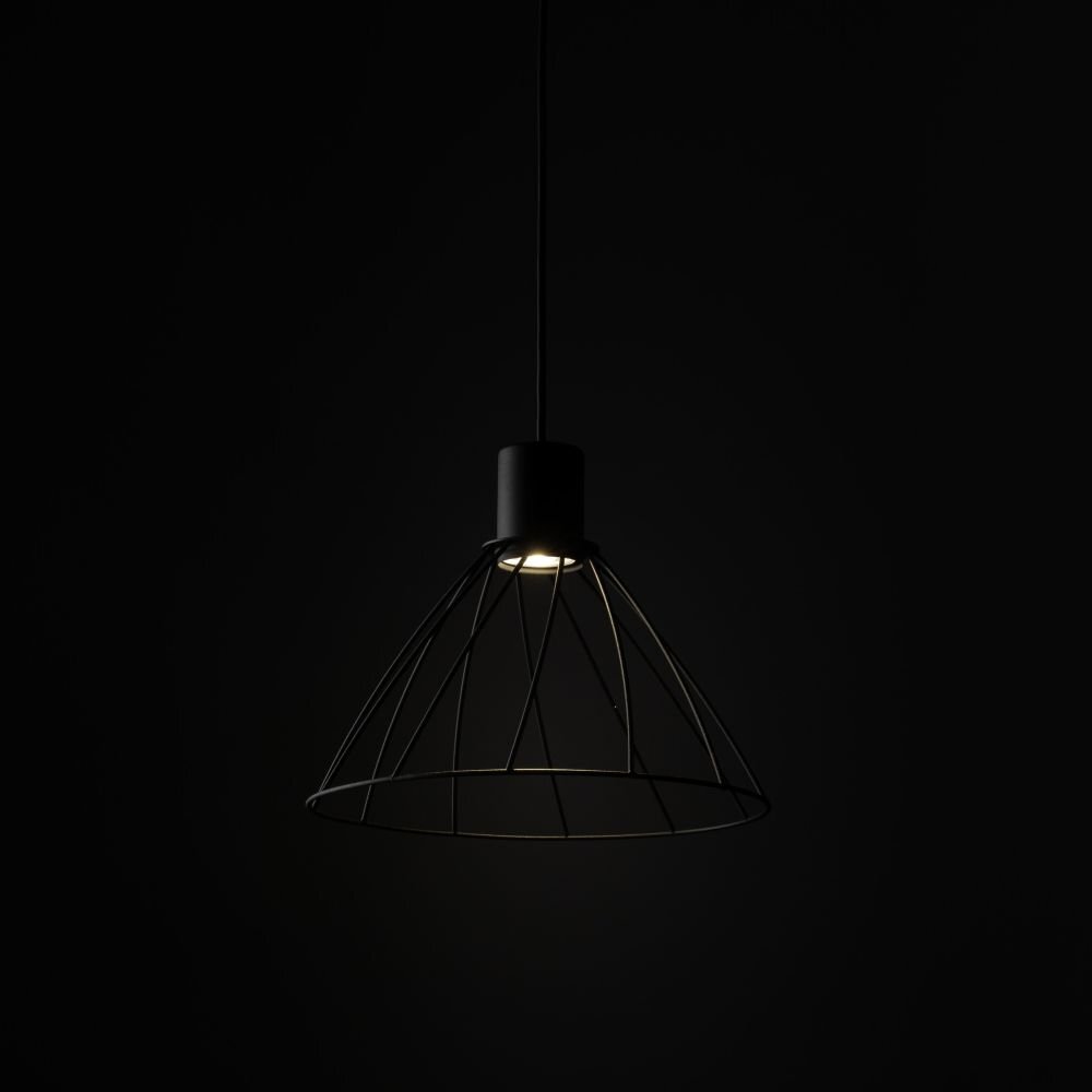 Czarna lampa wisząca z metalowym kloszem w kształcie stożka, emitująca światło z żarówki umieszczonej wewnątrz. Lampa zawieszona jest na cienkim przewodzie, widoczna na ciemnym tle.