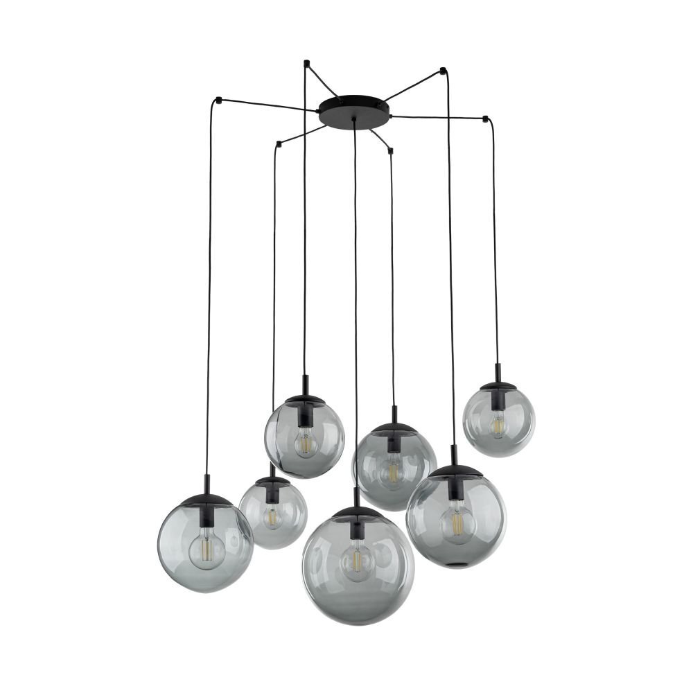 Na obrazie widoczna jest nowoczesna lampa wisząca z siedmioma szklanymi kloszami w kształcie kul, zawieszonymi na czarnych przewodach. Klosze są przezroczyste, a wewnątrz nich znajdują się żarówki.