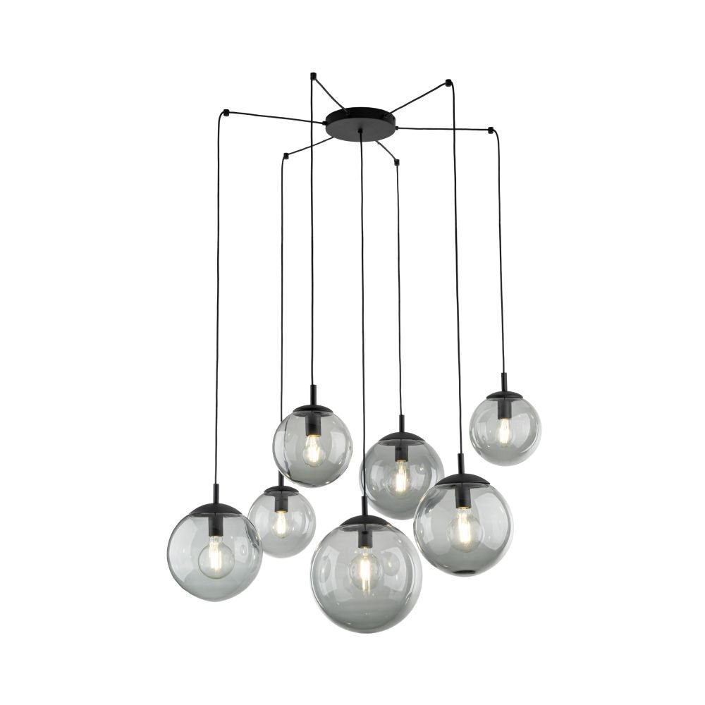 Na obrazie widoczna jest nowoczesna lampa wisząca z siedmioma szklanymi kloszami w kształcie kul, zawieszonymi na czarnych przewodach. Klosze są przezroczyste, a wewnątrz nich znajdują się żarówki.