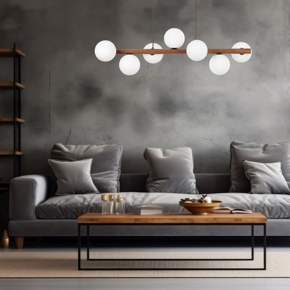 Na obrazie widoczna jest nowoczesna lampa wisząca z siedmioma białymi kloszami na drewnianej belce, zawieszona nad eleganckim salonem z szarą sofą i drewnianym stolikiem. W tle znajduje się szara ściana i półka z książkami.