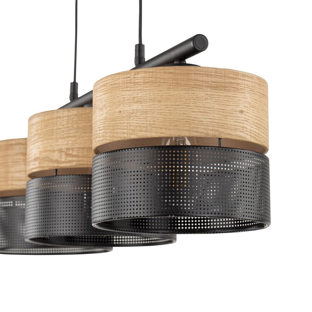 Lampa wisząca z trzema kloszami, wykonana z drewna w kolorze brązowym i perforowanego metalu w kolorze czarnym. Klosze mają cylindryczny kształt i są zawieszone na czarnych przewodach.
