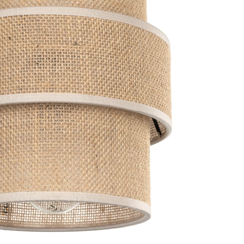 Lampa wisząca z beżowej juty z czarnymi elementami, o cylindrycznym kształcie i widocznym żarówkowym oprawie wewnątrz. Powierzchnia lampy ma teksturę przypominającą tkaninę jutową.