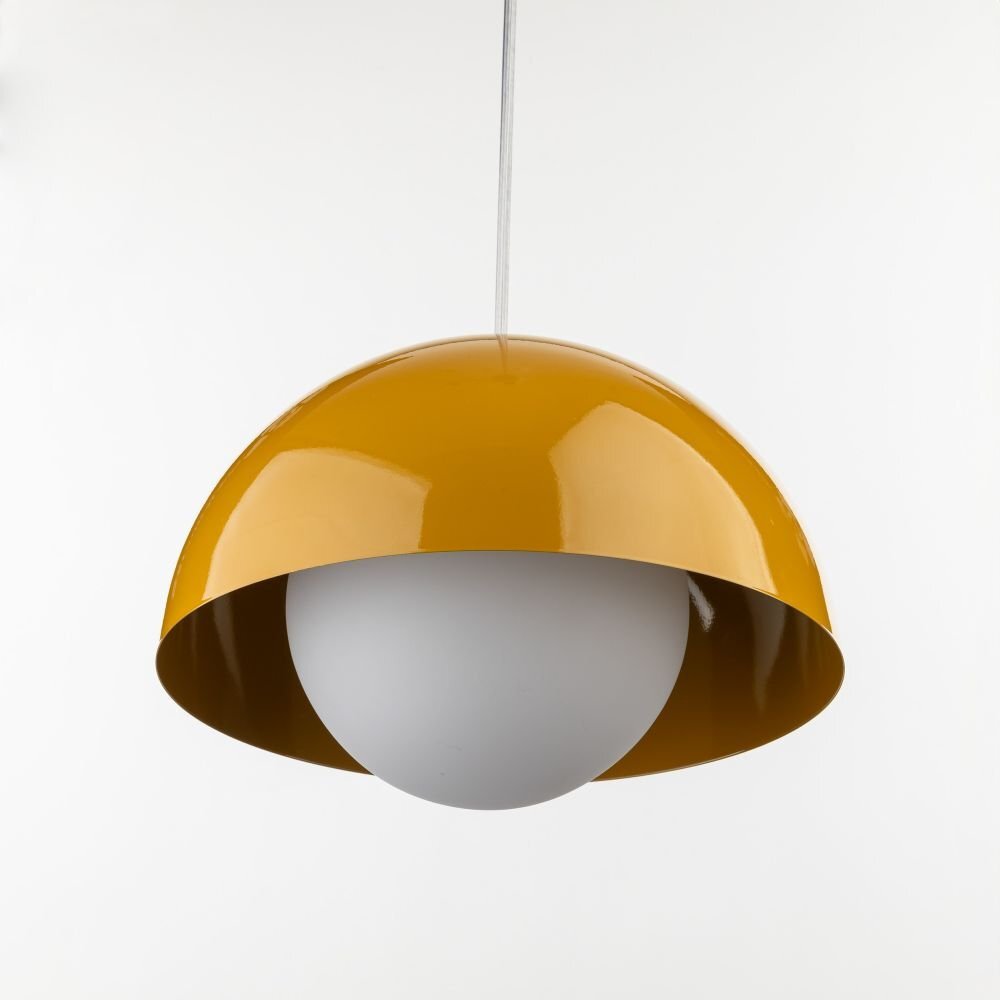 Lampa wisząca z żółtym, półokrągłym kloszem i białą kulistą żarówką wewnątrz. Lampa zawieszona jest na białym przewodzie.