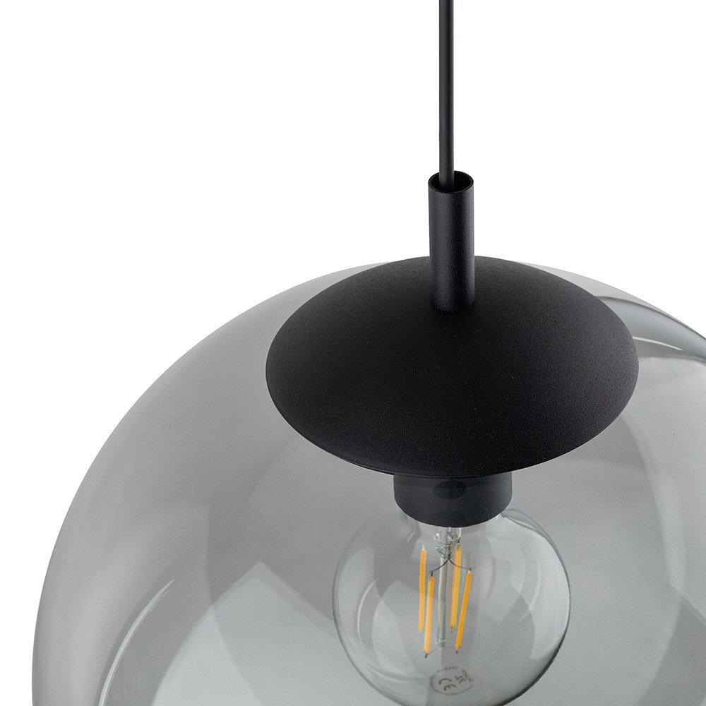 Zdjęcie przedstawia zbliżenie na górną część lampy wiszącej z grafitowym kloszem i widoczną żarówką wewnątrz. Lampa ma nowoczesny design z czarnym elementem mocującym.