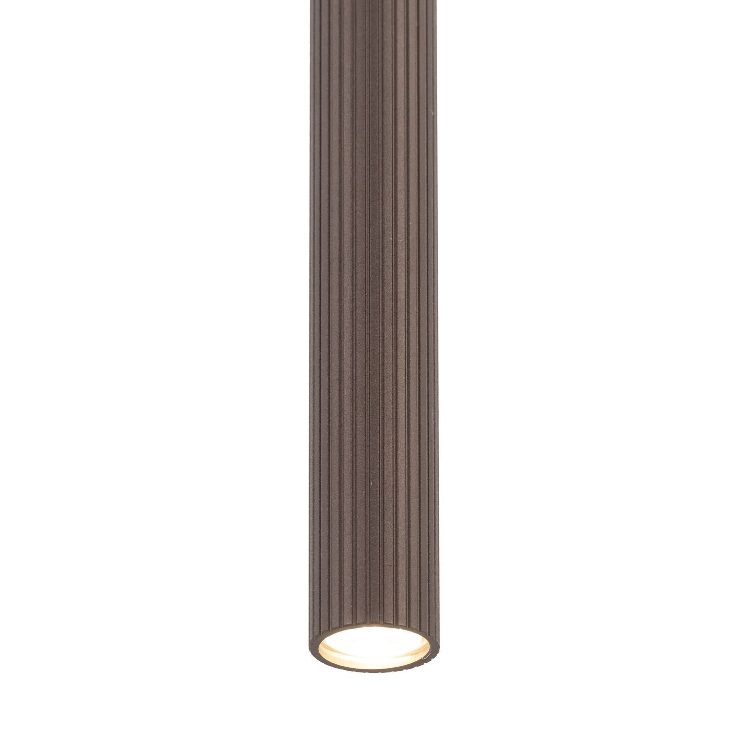 Cylindryczna lampa w kolorze brązowym z pionowymi żłobieniami, emitująca światło z dolnej części. Lampa ma prosty, nowoczesny design.