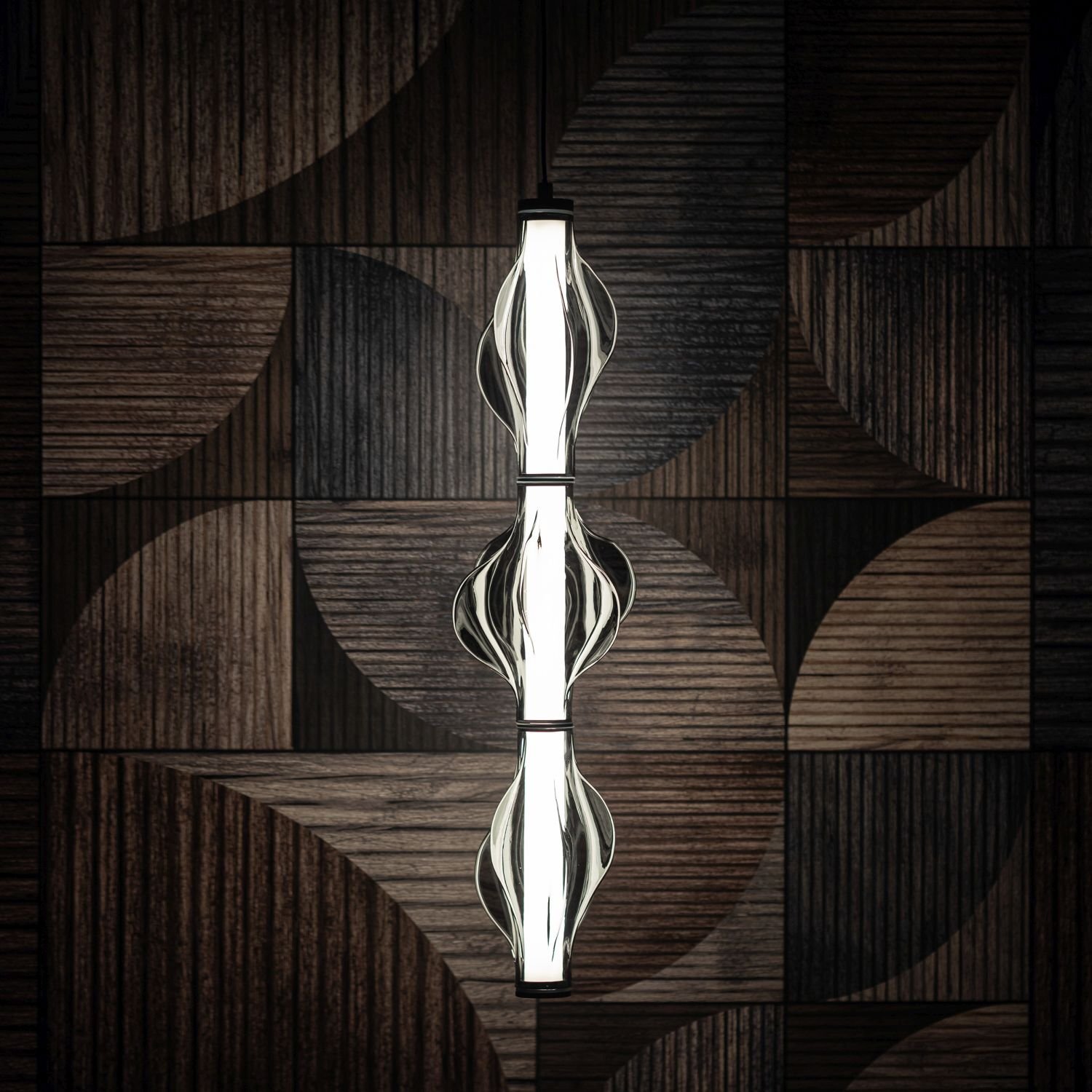 Nowoczesna lampa wisząca LED z trzema źródłami światła, umieszczona na tle ciemnej, geometrycznej ściany. Lampa ma czarną obudowę i szklane elementy o falistym kształcie.