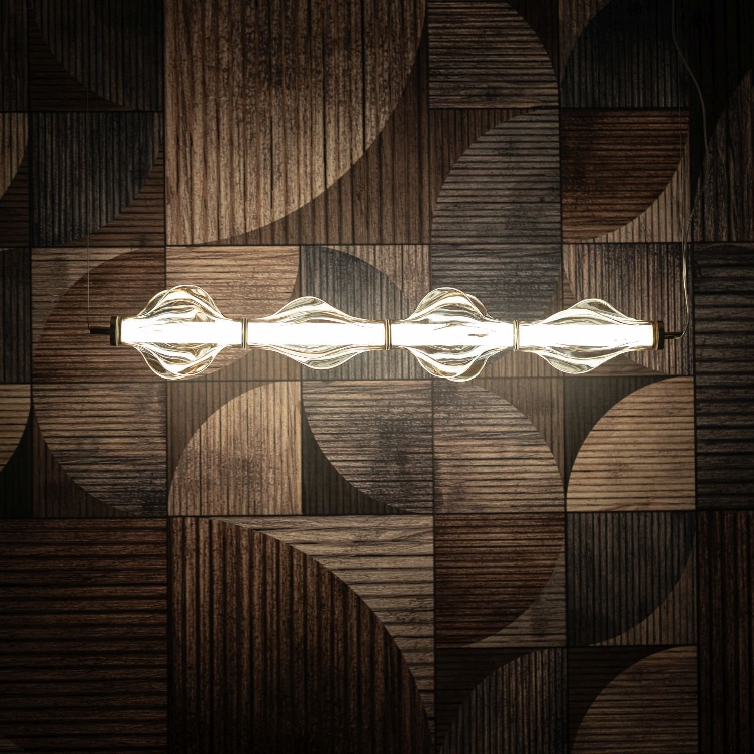 Lampa wisząca LED z czterema żarówkami w szklanych kloszach, zamontowana na tle ściany z drewnianymi panelami o geometrycznym wzorze.