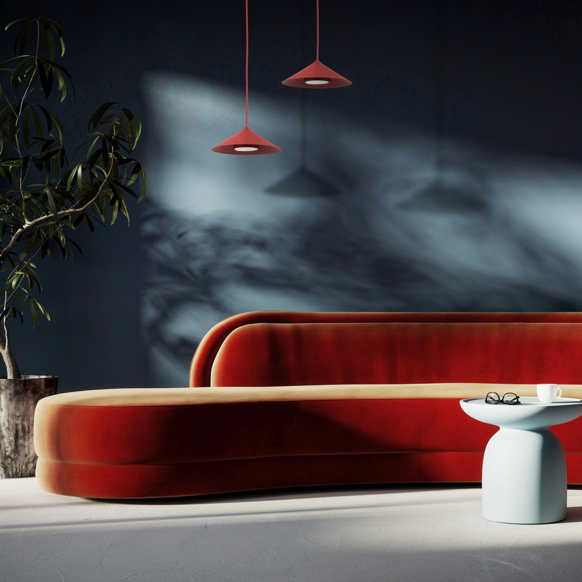 Na obrazie widoczne są dwie wiszące lampy w kolorze burgundowym oraz czerwono-beżowa sofa na tle ciemnej ściany. Obok sofy stoi biały stolik z filiżanką i okularami.