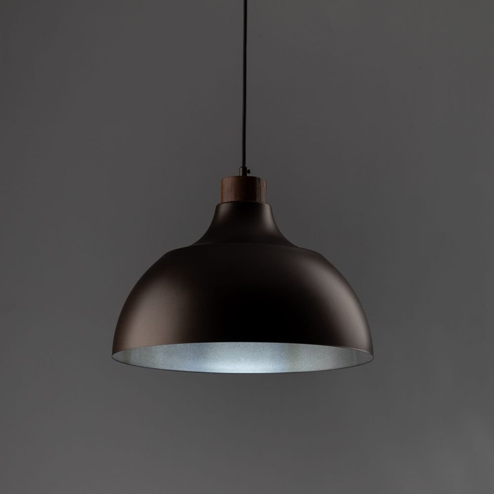 Na obrazie widoczna jest lampa wisząca o ciemnobrązowym kloszu z drewnianym elementem przy zawieszeniu. Tło jest jednolite i ciemnoszare.