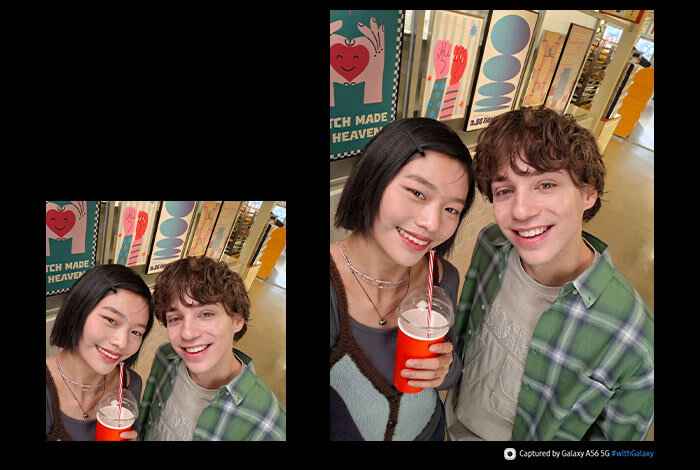 Dwie osoby stoją w pomieszczeniu, trzymając napoje w czerwonych kubkach. W tle widoczne są plakaty z napisami \'MATCH MADE IN HEAVEN\' oraz \'Captured by Galaxy A56 5G #withGalaxy\'.