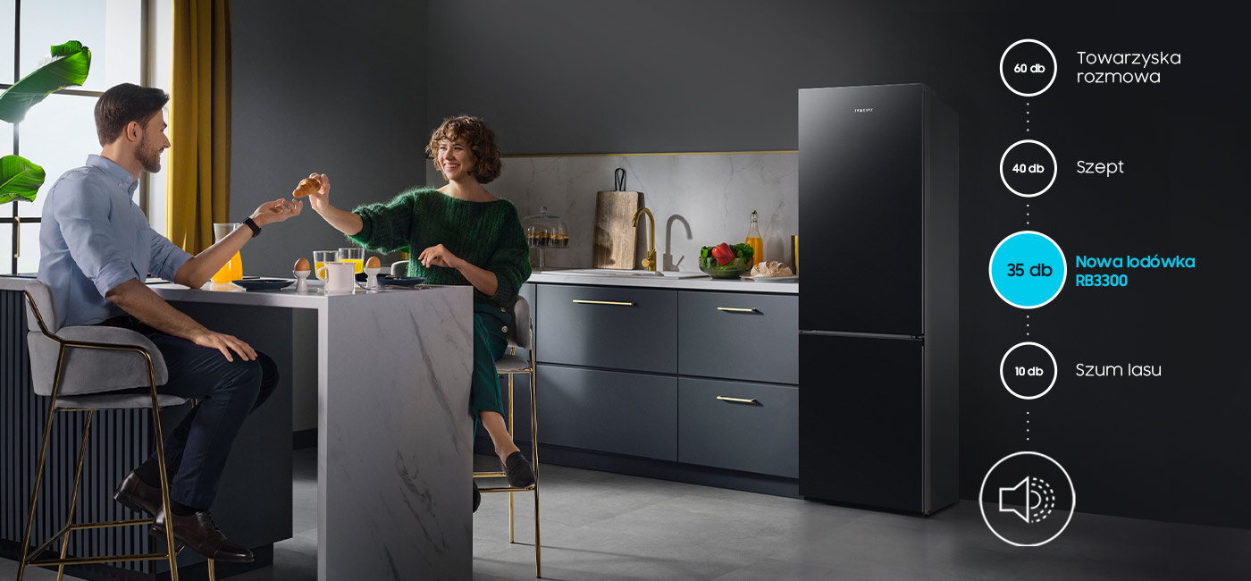 W kuchni przy stole siedzą dwie osoby, a obok znajduje się czarna lodówka. Na obrazie widoczna jest grafika z poziomami hałasu: 60 dB Towarzyska rozmowa, 40 dB Szept, 35 dB Nowa lodówka RB3300, 10 dB Szum lasu.