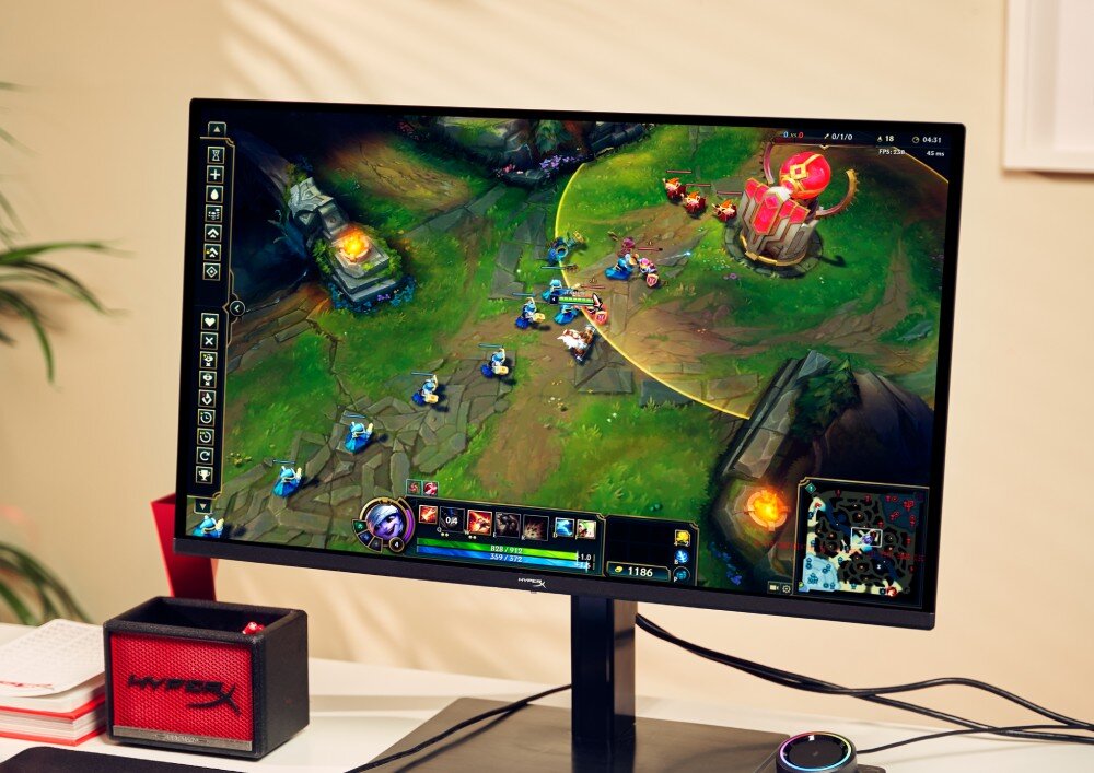 Monitor HYPERX Omen 27q Osoba grająca w 'League of Legends' na monitorze z widocznym kontrolerem audio obok klawiatury