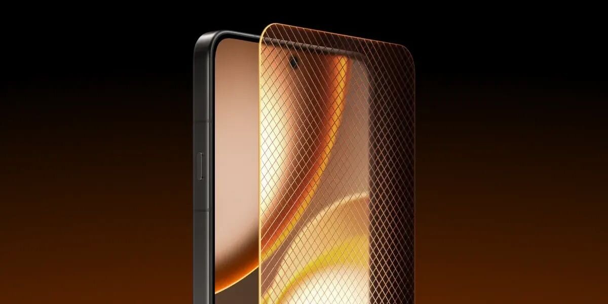 Obraz przedstawia smartfon z dużym ekranem, na którym widoczny jest abstrakcyjny wzór w odcieniach pomarańczowego i złotego. Na ekranie znajduje się cienka siatka ochronna.