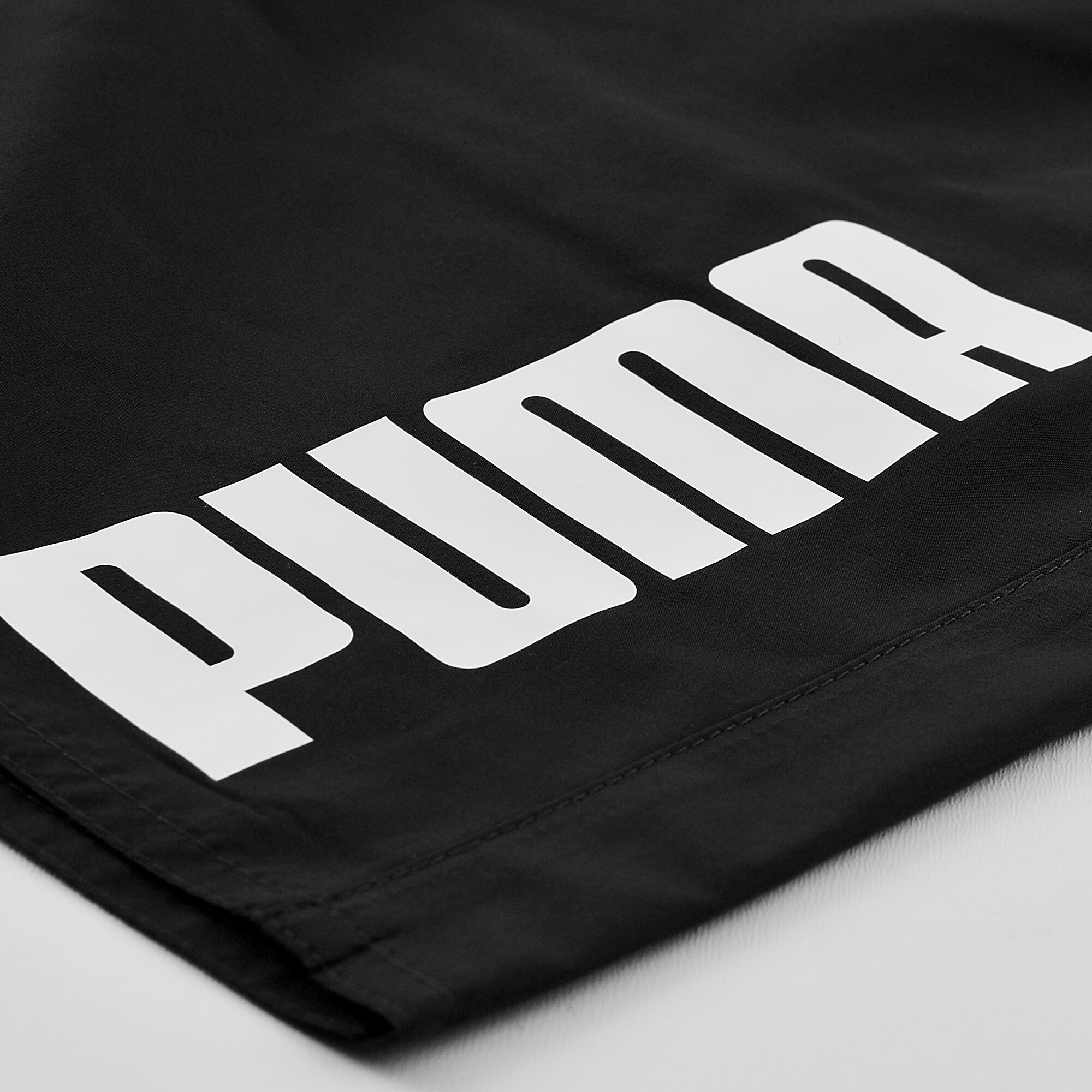 Czarne kąpielówki z białym napisem \'PUMA\' na materiale.