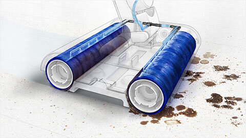 Obraz przedstawia elektryczny mop z dwoma niebieskimi, obrotowymi wałkami czyszczącymi, które usuwają zabrudzenia z podłogi. Widoczne są ślady brudu przed mopem oraz czysta powierzchnia za nim.